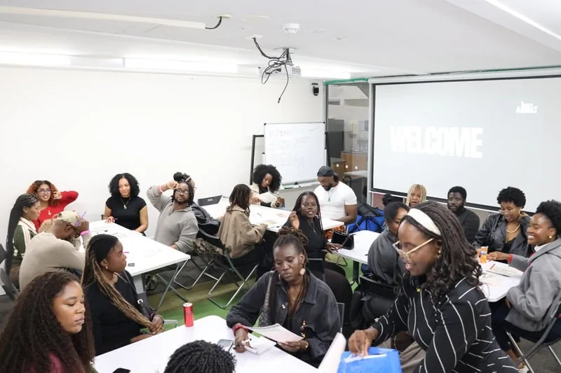 A full Inner Architect workshop room, groups working at tables